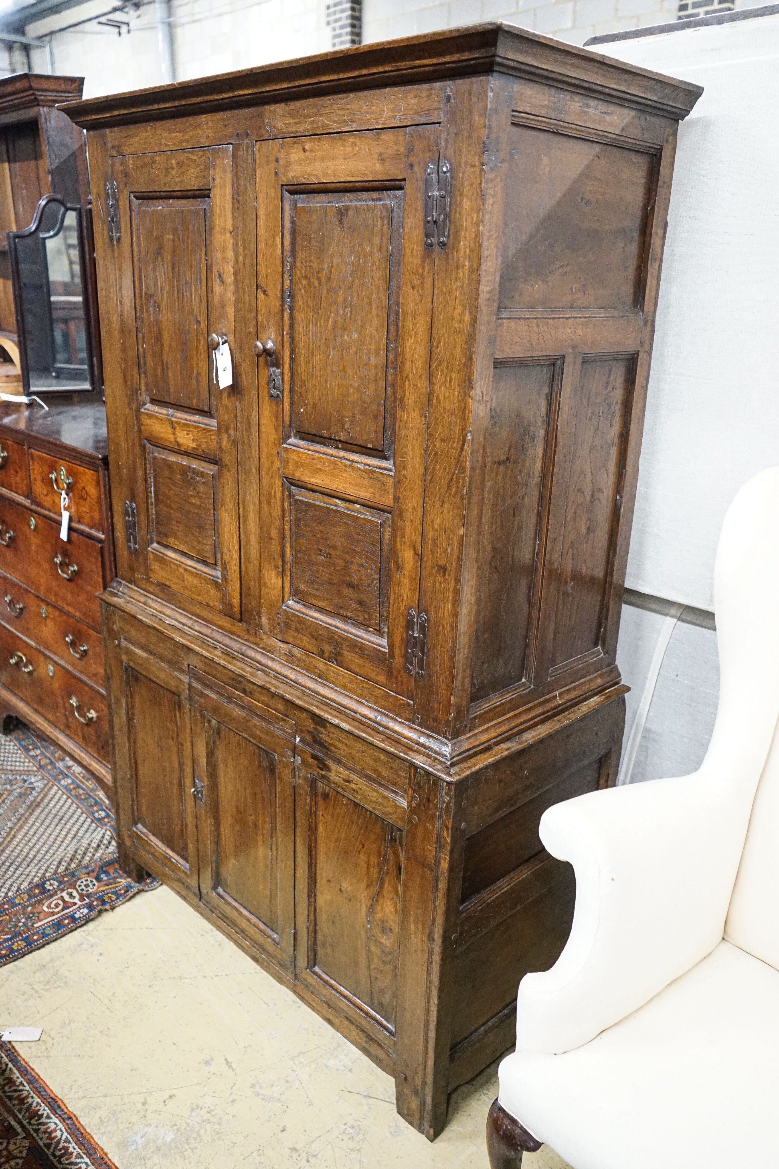A 17th century style oak press cupboard, with three panelled doors, width 108cm, depth 50cm, height 172cm